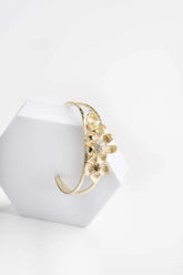 Bracciale rigido alla schiava con dettaglio floreale.