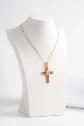 Ciondolo a forma di croce, con cammeo inciso a mano e dettaglio in corallo. Catena in argento inclusa