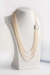 Collana multifilo in perle di acqua dolce composta da tre fili degradé con chiusura a cammeo. Chiusura-cammeo di 3 × 3 cm.