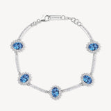 Bracciale Kate semirigido in argento rodiato 925‰ con oval cubic zirconia chiari e colore sapphire. Lunghezza 18cm.